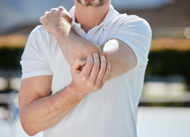 Elbow, pain and person with injury, fitness and athlete outdoor, medical emergency and joint inflam.