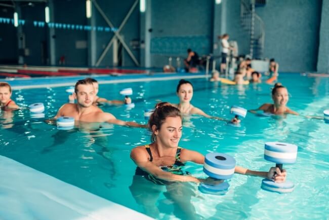 Group of people doing water therapy in indoor pool
