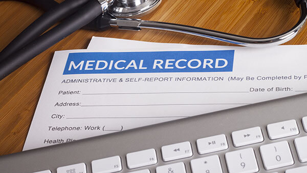 Stethoscope resting on a sheet of medical insurance records