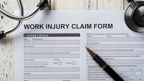 top view work injury claim form with stethoscope  and box of pills medical and insurance concept