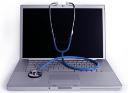 laptop with a stethoscope draped over it
