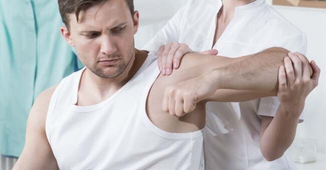 Man having shoulder examined by doctor